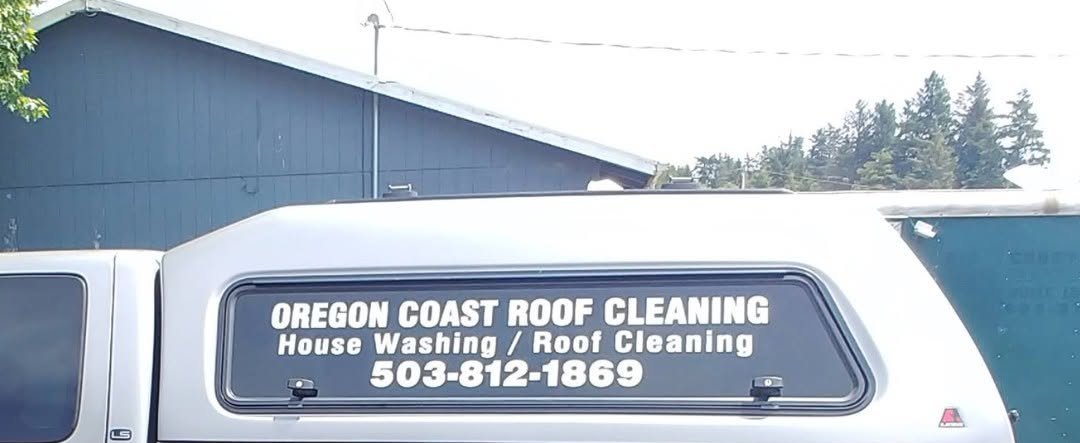 White service vehicle with Oregon Coast Roof Cleaning business signage and phone number displayed on rear window