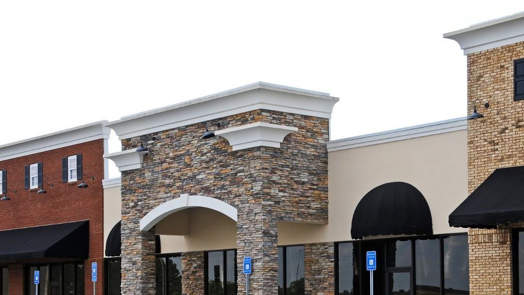 Modern commercial building exterior with stone archway and brick facade
