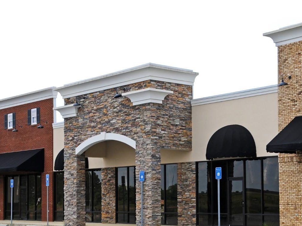 Modern commercial building exterior with stone archway and brick facade